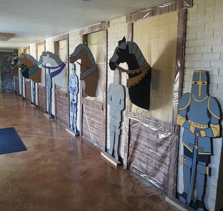 several paper cutouts of horses and armor are on display in a room with brick walls