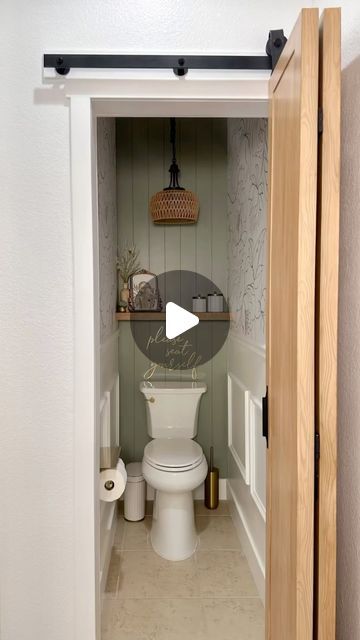 a white toilet sitting inside of a bathroom next to a wooden door with a mirror above it