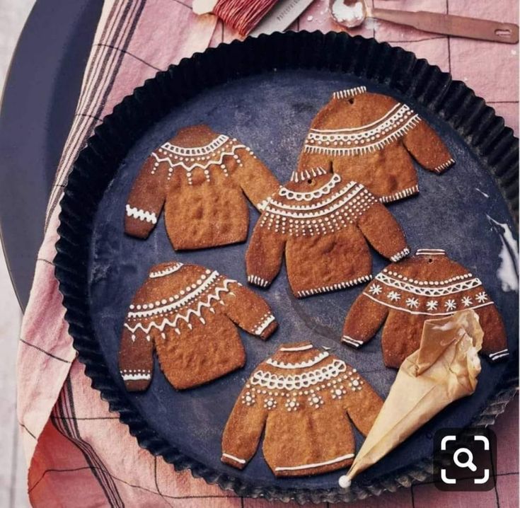 a pan filled with cut out gingerbreads on top of a table next to utensils