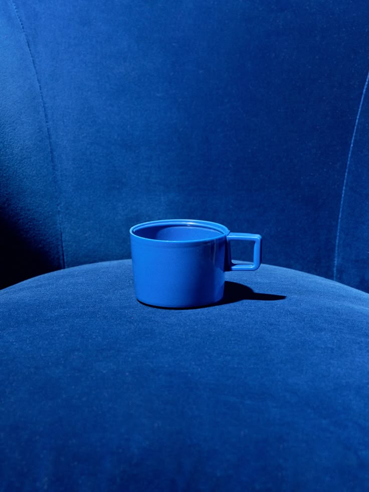 a blue cup sitting on the back of a chair