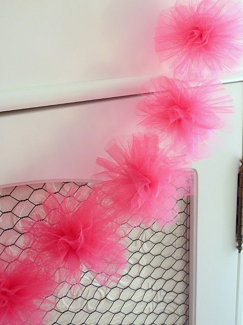 pink tulle pom - pom garland hanging from the side of a door