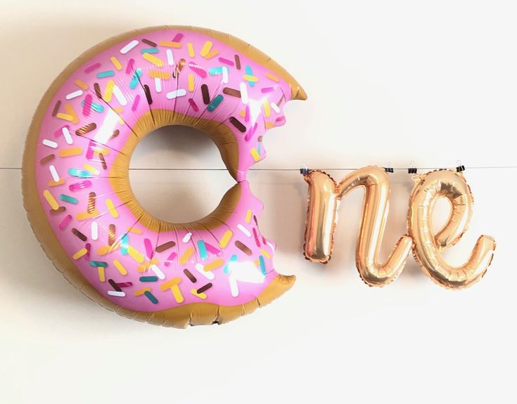 a pink donut with sprinkles and the word yes spelled out next to it