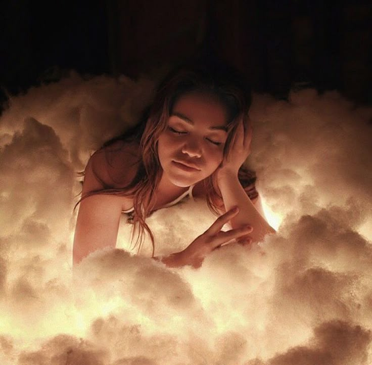 a woman is sitting in the clouds with her hands on her head