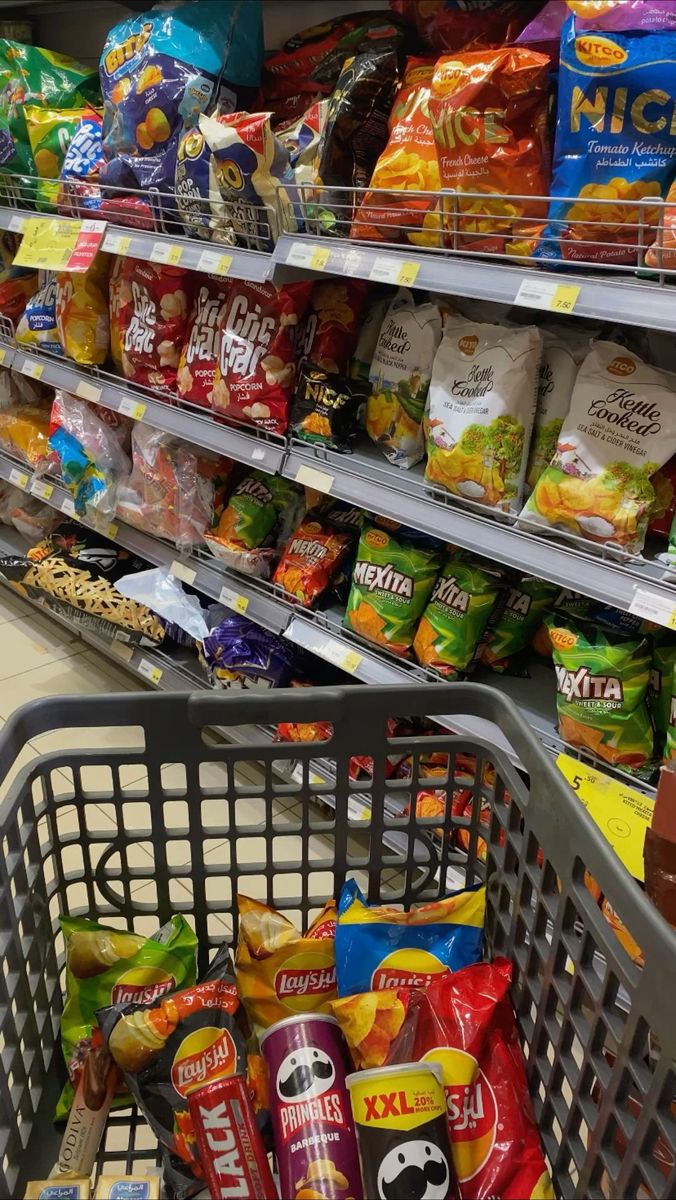 a shopping cart filled with lots of food in a grocery store's produce aisle