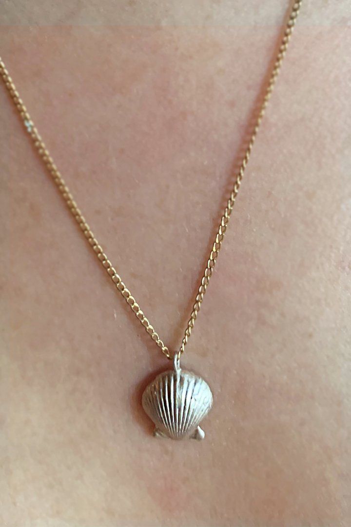 Dainty yet wise, this sweet sterling silver scalloped shell holds many secrets of creatures from the deep, perhaps some will bubble up to you while donning this lovely necklace. Scalloped seashells are associated with love and travel. Invoke the Goddess Aphrodite for all your love and beauty needs by using these shells in your love potions or wearing this symbol around your neck. A sterling silver shell with a gold fill 20" chain. This piece is MADE TO ORDER by our in-house designer and owner, f Trendy Silver Shell Jewelry With Oyster Bracelet, Dainty Shell Necklaces Perfect As Gifts, Shell Pendant Charm Necklaces For Gifts, Silver Shell Jewelry, Unique Silver Shell As A Gift, Silver Shell Necklace As A Gift, Silver Shell Gift, Silver Shell Necklace Perfect For Gifts, Unique Silver Shell Jewelry