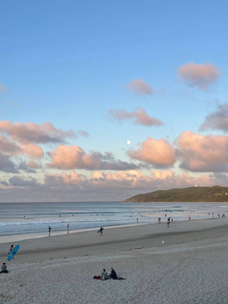 many people are on the beach and one person is flying a kite in the sky