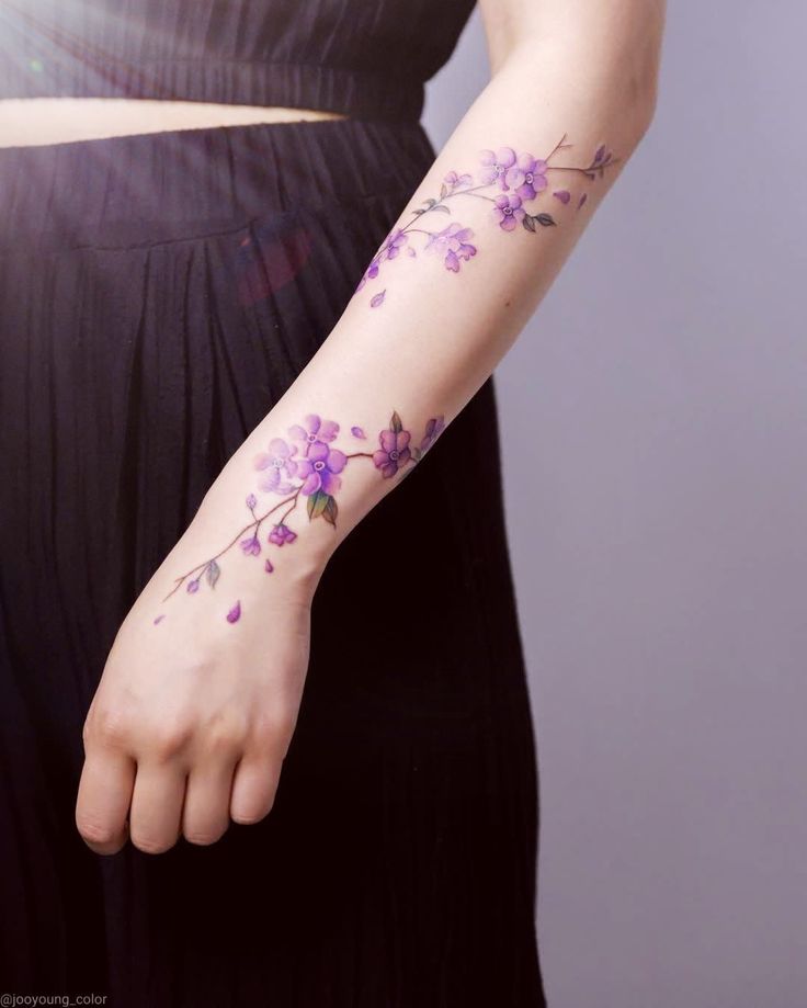 a woman's arm with purple flowers on it