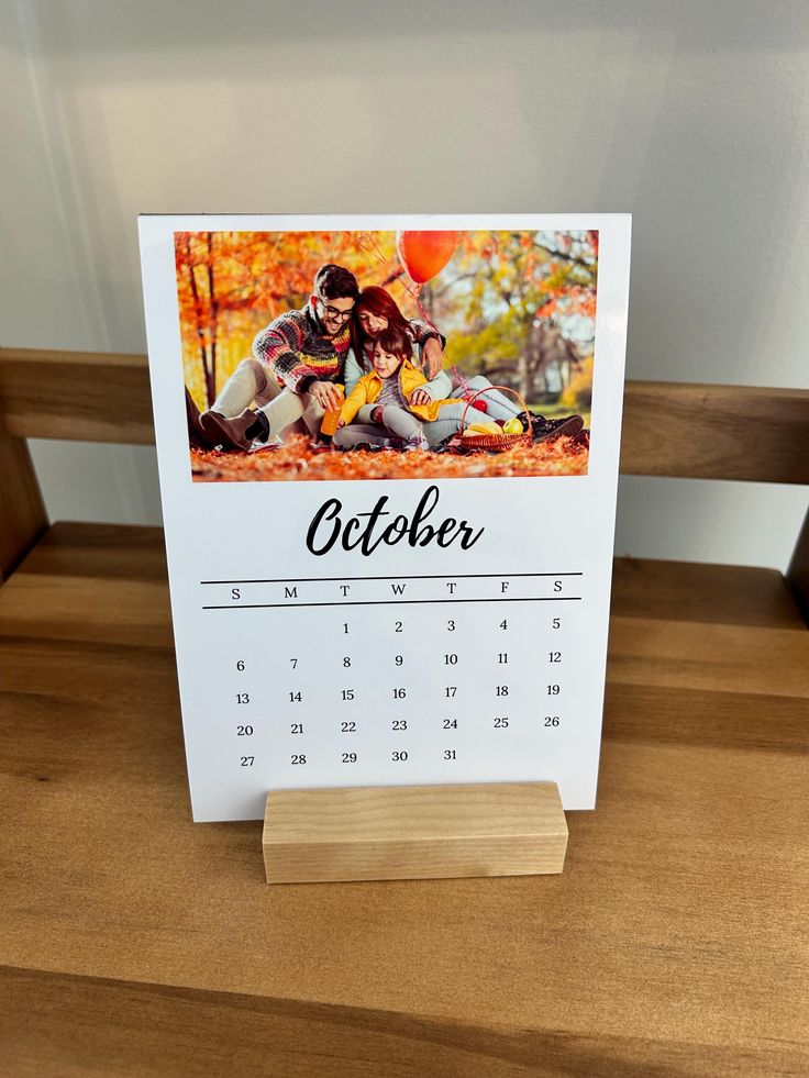 a desk calendar with an image of a couple on it sitting on top of a wooden bench