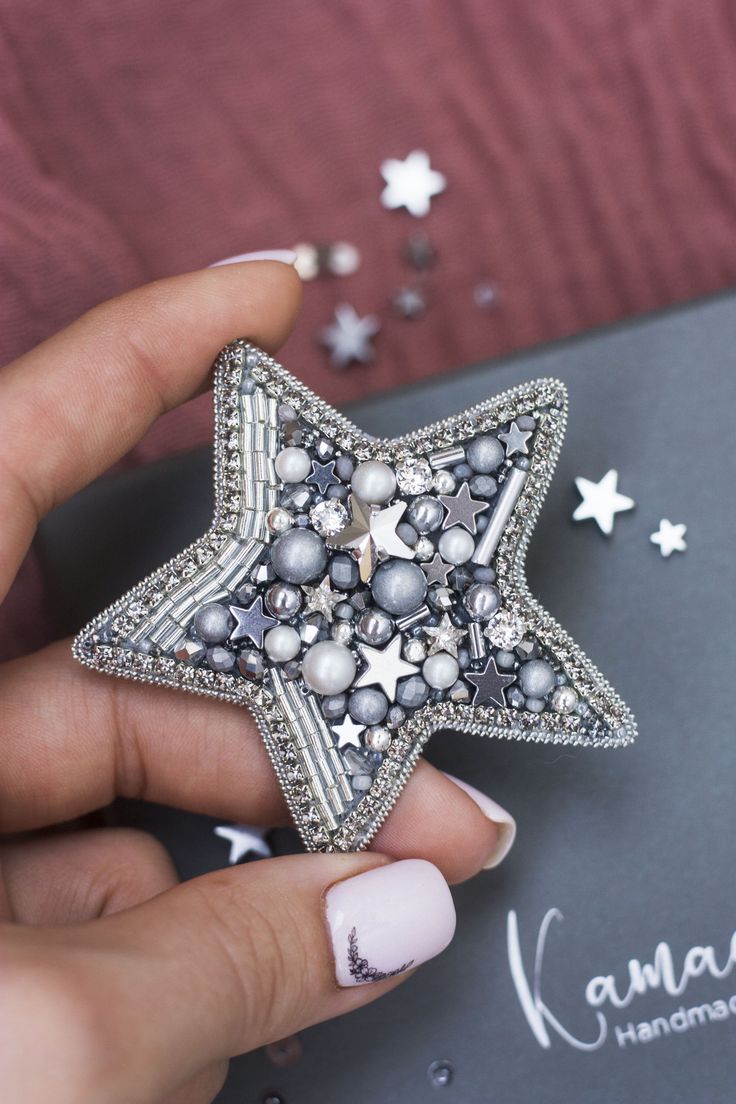 a person holding a star brooch in their hand