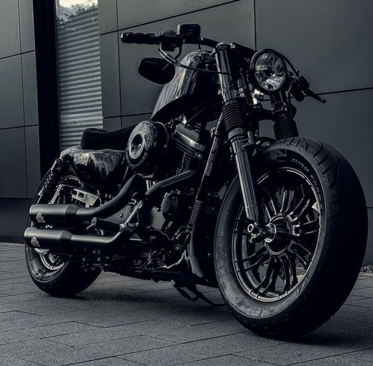 a black motorcycle parked in front of a building