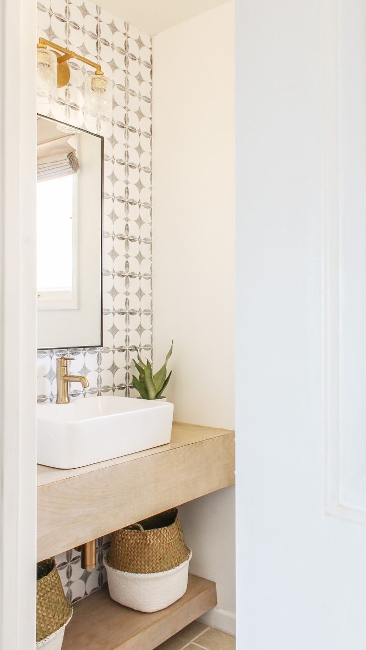 a bathroom sink sitting under a mirror next to a wall