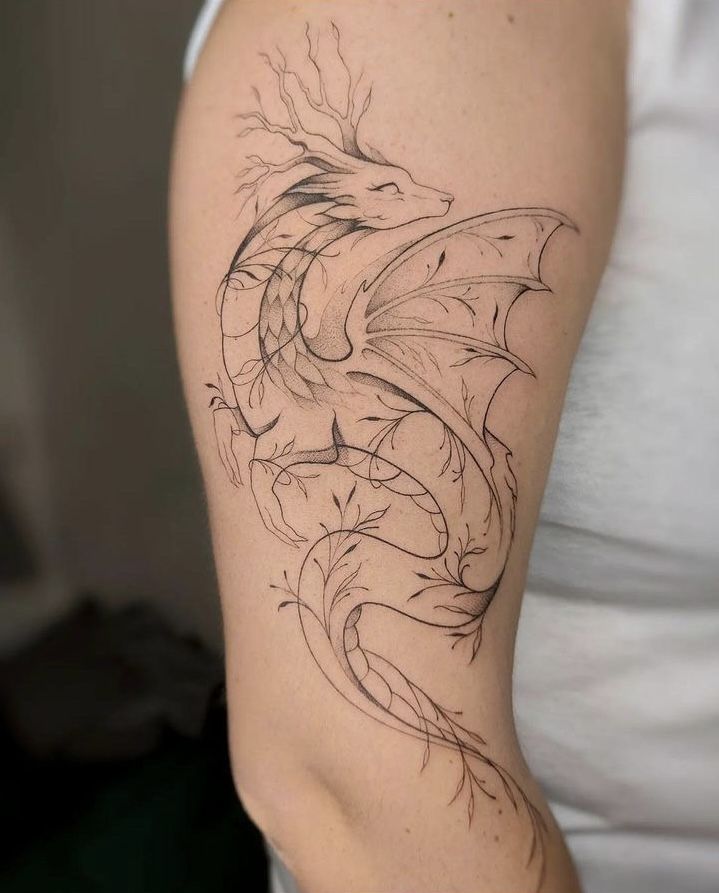 a woman's arm with a dragon tattoo on the left side of her body