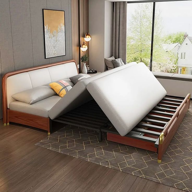 a bed with two mattresses on top of it in front of a large window