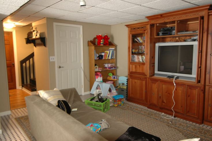 a living room filled with furniture and a flat screen tv sitting on top of a wooden entertainment center