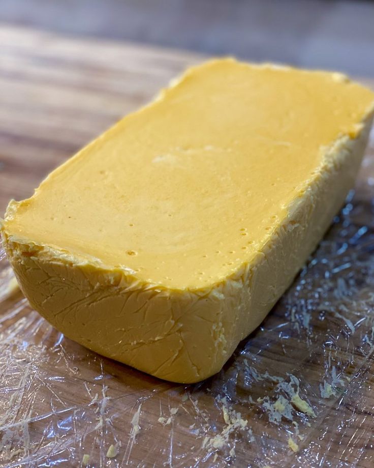 a block of butter sitting on top of a wooden cutting board