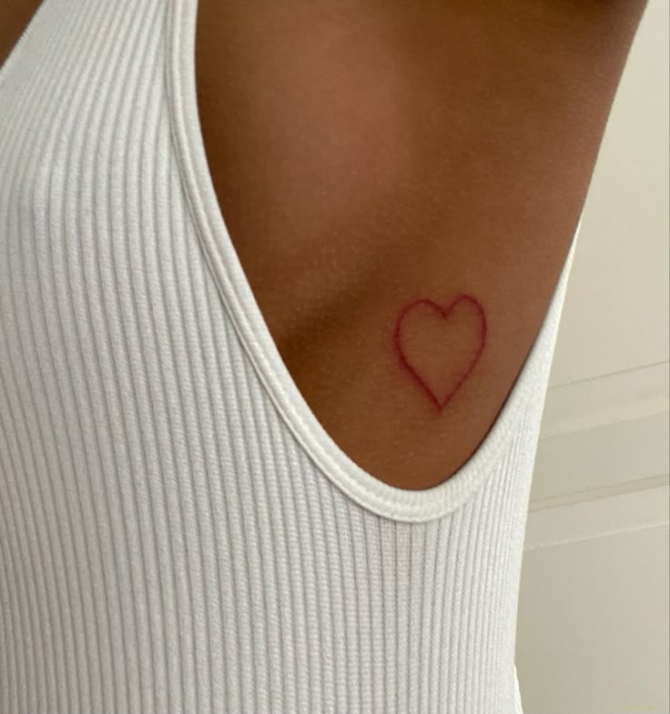 a woman with a heart tattoo on her chest