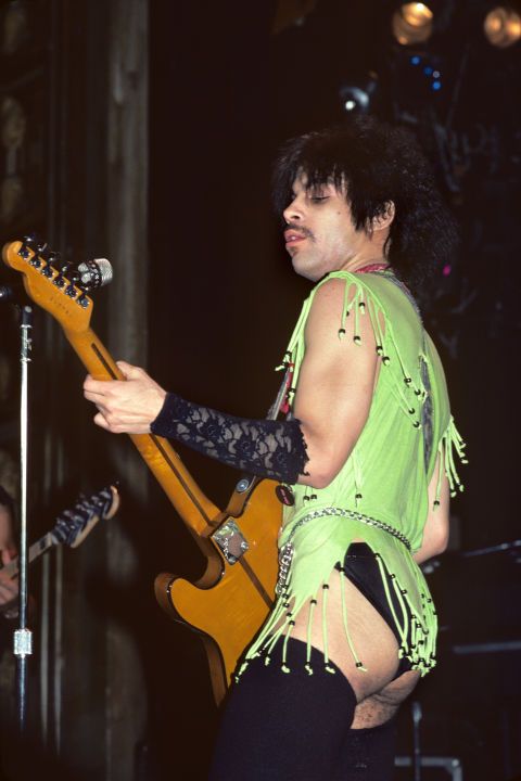 a man in green shirt playing guitar on stage