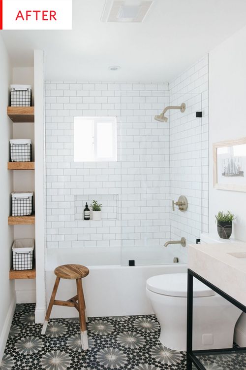 a white bathroom with black and white tile flooring, shelving units and a wooden stool