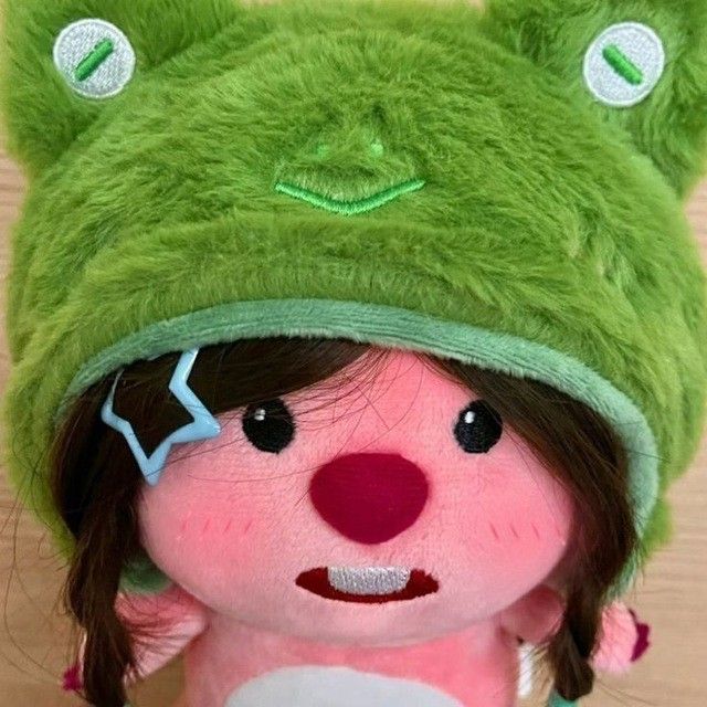 a small stuffed animal wearing a green hat