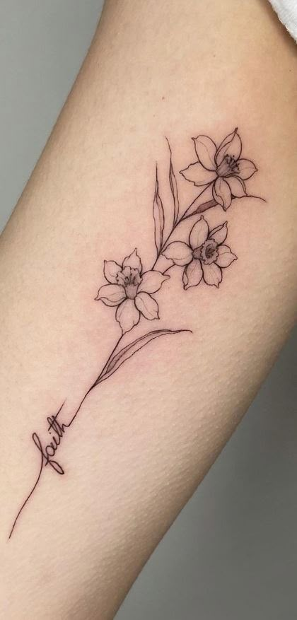 a small flower tattoo on the left arm and leg, with an arrow in the middle