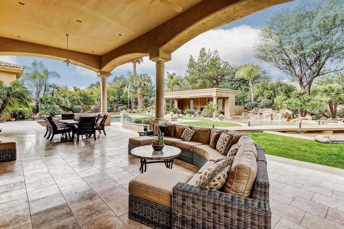 an outdoor living area with couches and tables