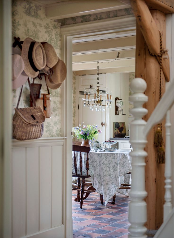 a dining room with a table, chairs and hats hanging on the wall above it