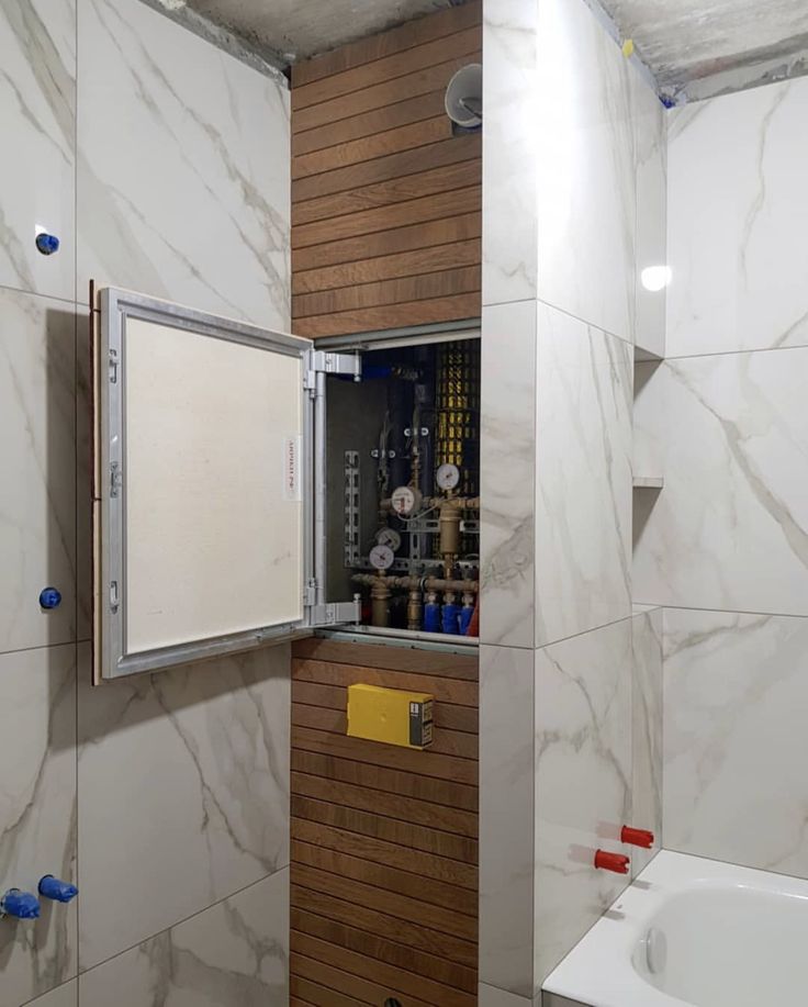 a bathroom with white marble walls and wood trim