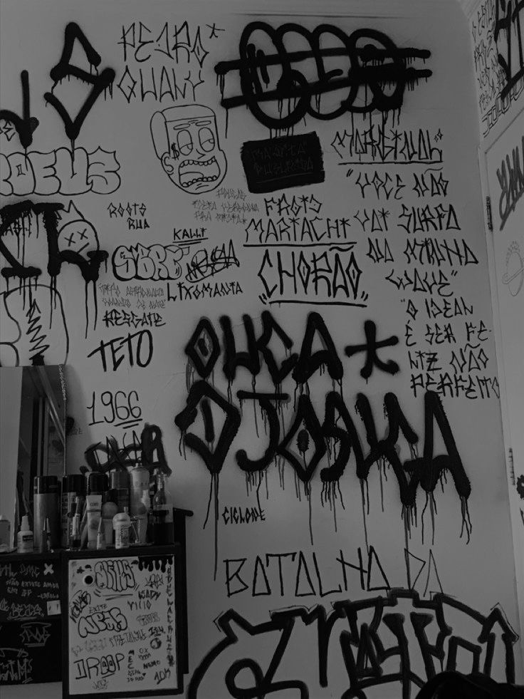 the wall is covered with black graffiti and other writing, including words that spell out