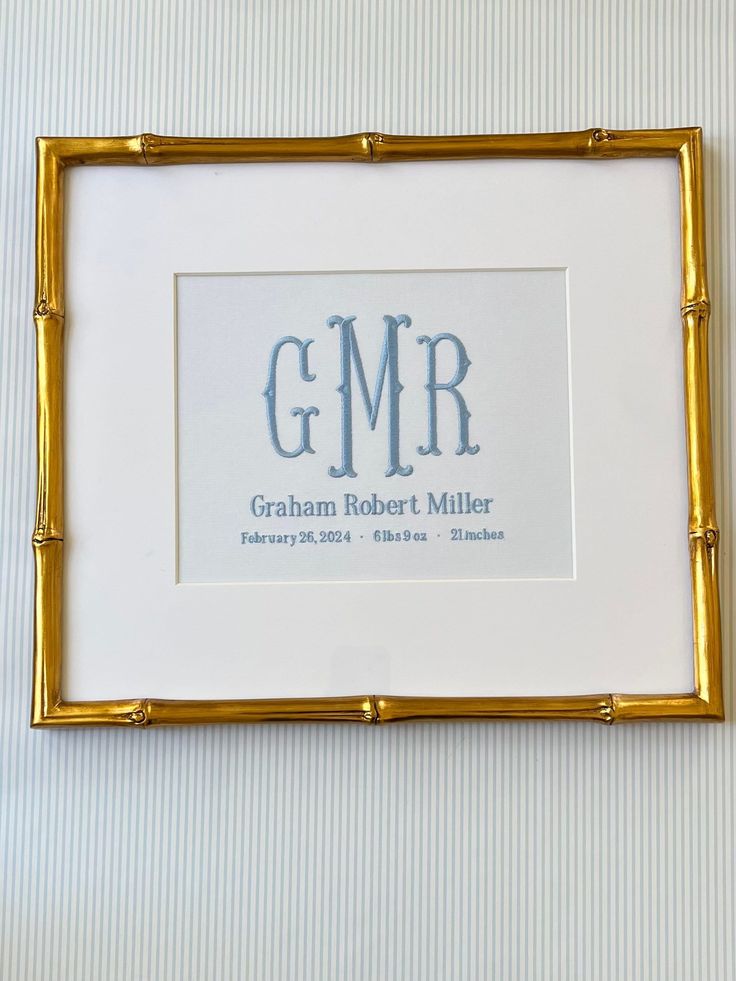 a white and gold frame with the words graham robert miller in blue ink on it