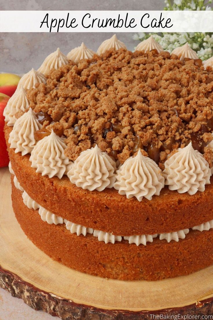 a cake with white frosting and crumbs is on a wooden platter