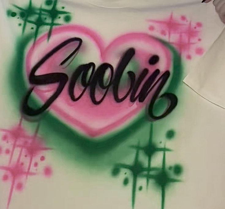 graffiti on the back of a white shirt that says goobin in pink and green