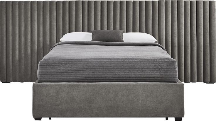 a bed with a gray headboard and foot board next to a white pillow on top of it