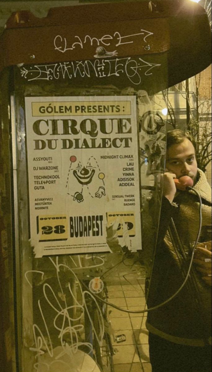 a woman talking on a cell phone in front of a sign that says golem presents cirque du dialect