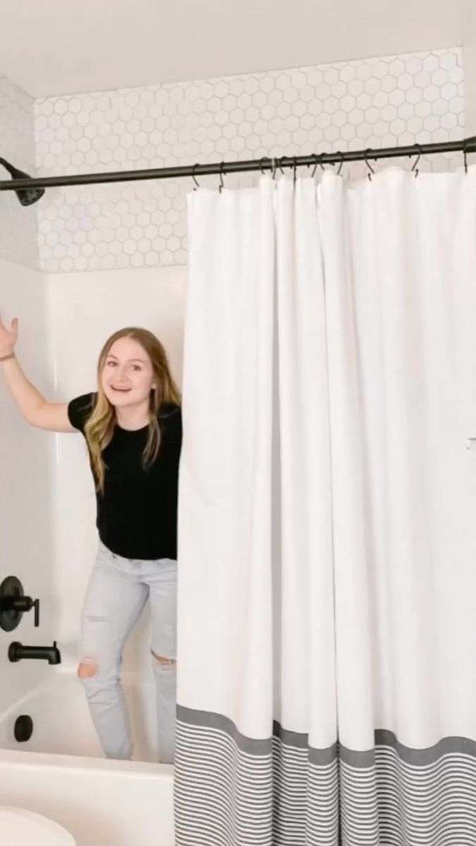 a woman standing in front of a shower curtain