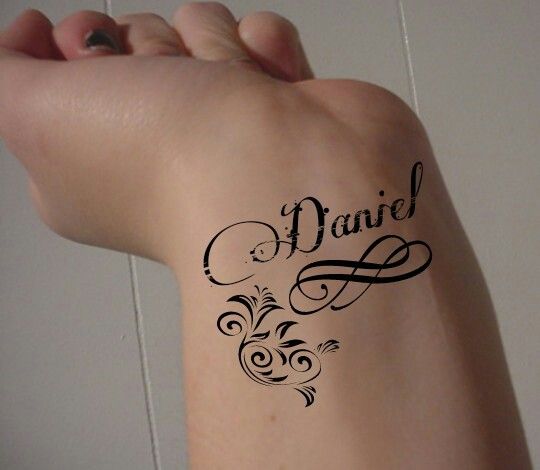 a woman's arm with a tattoo on it that says, daniel and is written in cursive writing