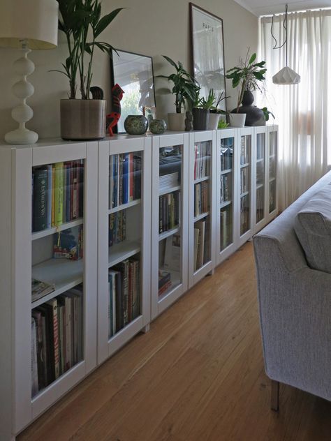 a living room filled with lots of books and plants