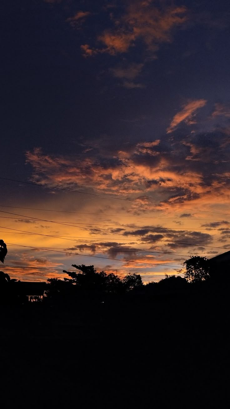 the sun is setting over some trees and buildings