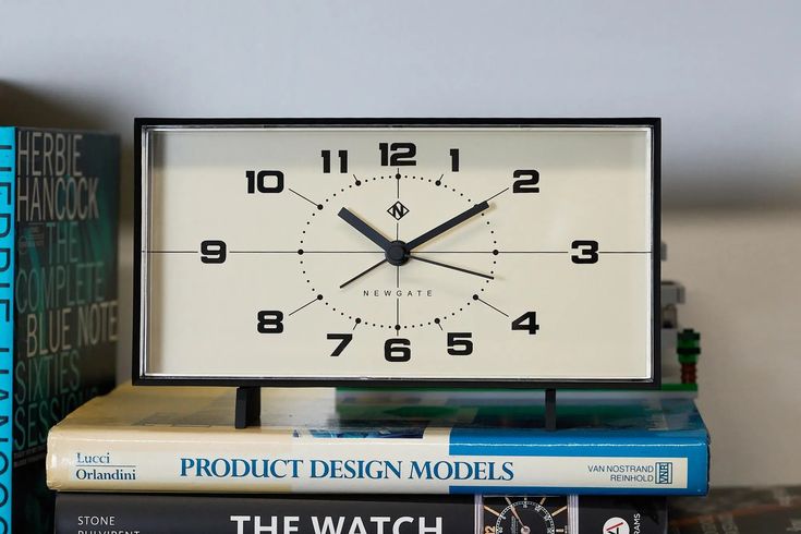 a clock sitting on top of a stack of books