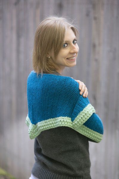 a woman wearing a blue and green knitted sweater