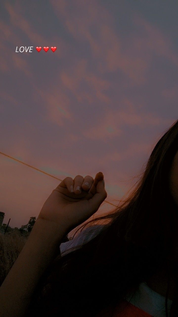 a woman is holding her hand up to the sky with love written above her head