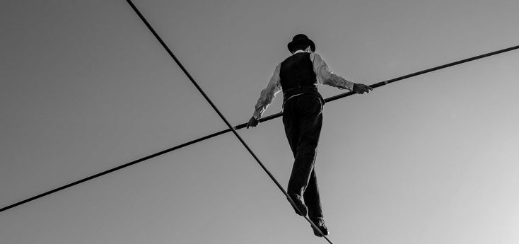 a man is walking across the high wire with his hands on one side and feet on another