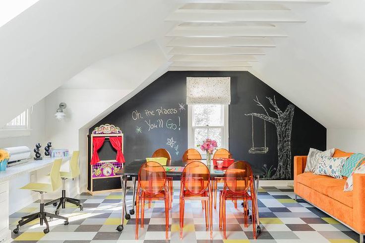 the room is decorated with black and white checkered flooring, orange chairs, and chalkboard walls