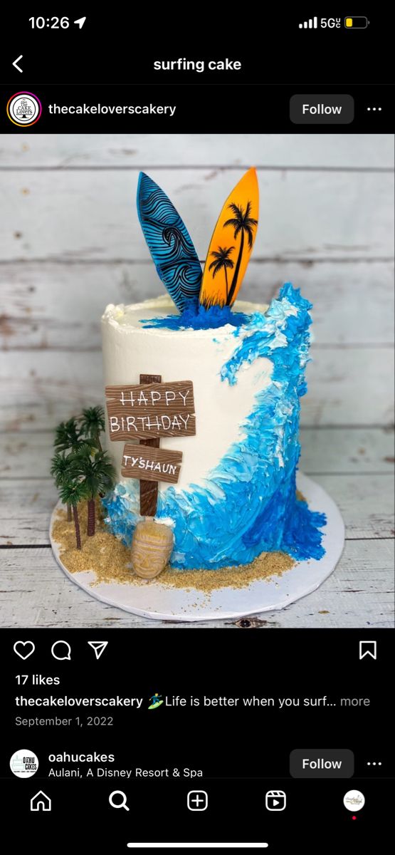 a birthday cake with surfboards and palm trees on the top is decorated in blue and white icing