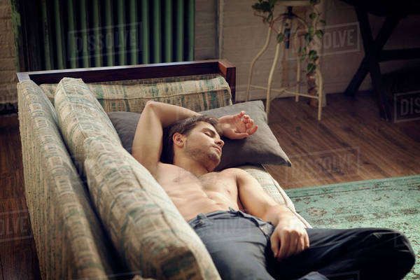 a man laying on top of a couch in a living room