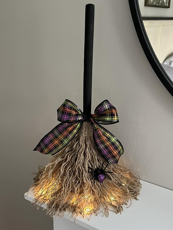 a lighted broom on top of a white shelf