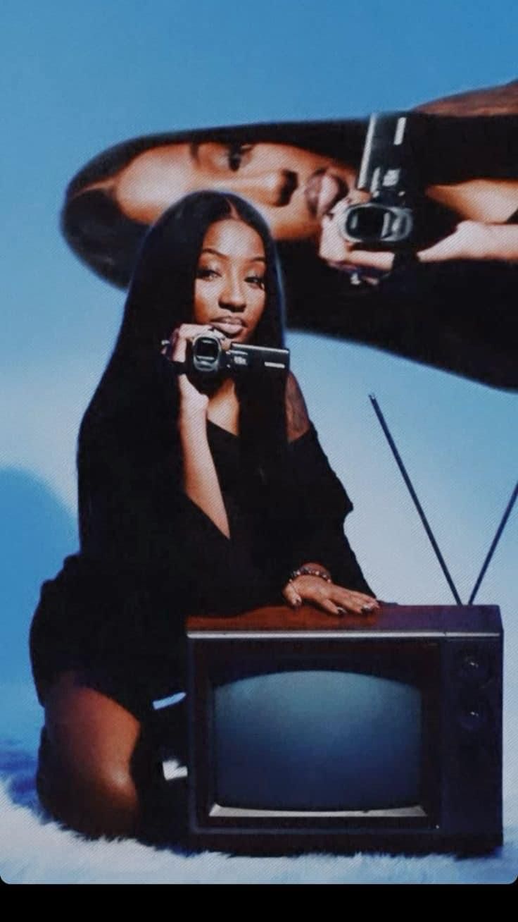 a woman sitting on the ground in front of a tv