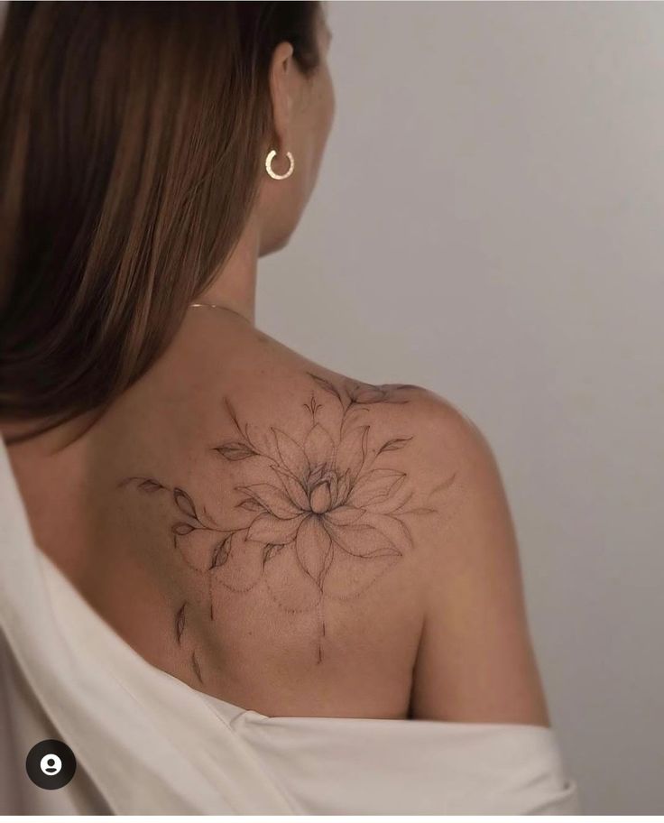 a woman with a flower tattoo on her back