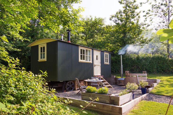 a small green house sitting on top of a lush green field