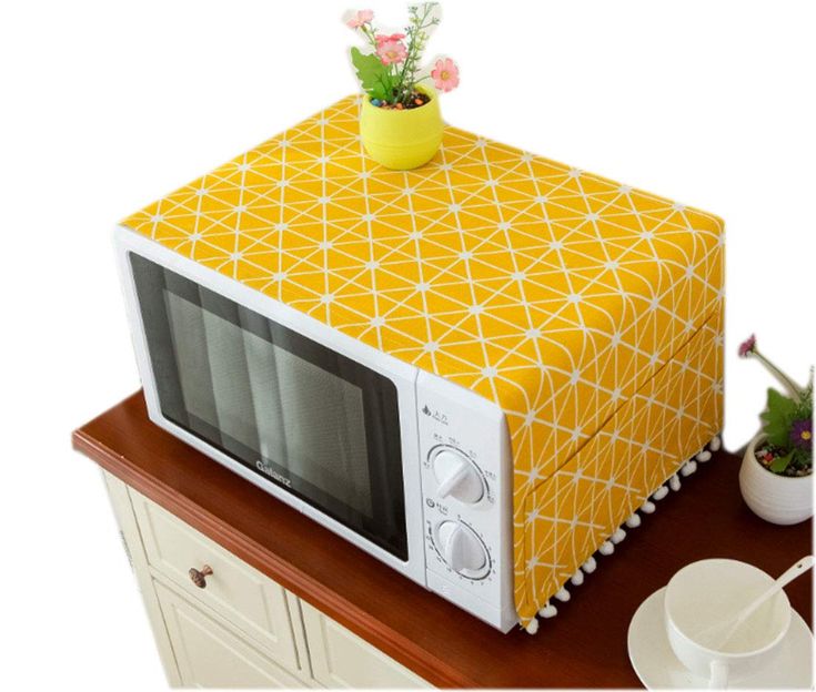 a microwave oven sitting on top of a wooden table next to a potted plant