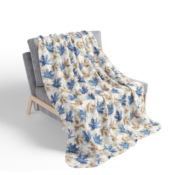 a blue and white blanket sitting on top of a gray couch next to a wooden frame